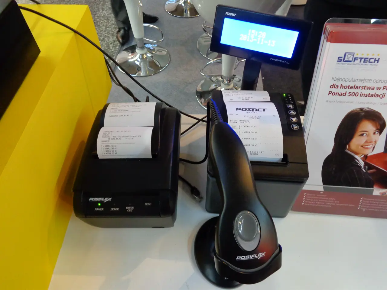Handheld barcode scanner, receipt printer, and order terminal on a hospitality trade-show counter